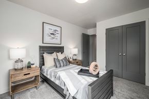 Pleasant Grove townhouse for rent - A bedroom with a large bed, a nightstand with a lamp, and a framed picture on the wall.