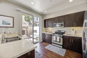 Santa Clarita townhouse for rent - a kitchen with a sink and stove and a door to a patio