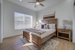 Draper apartment for rent - A bedroom with a bed, nightstand, and window with blinds.