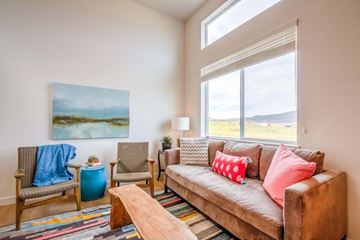 Bluffdale townhouse for rent - A living room with a brown couch, a blue chair, and a painting on the wall.