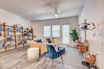 Colorado Springs apartment for rent - A living room with a blue chair and a bookshelf.
