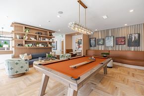 Orlando apartment for rent - A pool table is in the middle of a room with a couch and a chair.