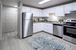 Corvallis apartment for rent - Kitchen with white cabinets and stainless steel appliances and a rug at Veri at Timberhill, Corvallis, 97330