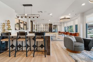 Tempe apartment for rent - a communal area with a bar and chairs and a living room with tables and chairs