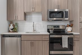 Tempe apartment for rent - a kitchen with stainless steel appliances and wooden cabinets