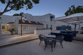 La Jolla apartment for rent - A patio with a table and chairs is set up outside a building.