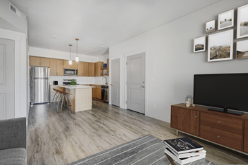 Layton apartment for rent - a living room with a tv and a kitchen with stainless steel appliances