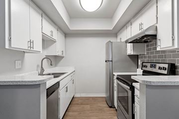 Tempe apartment for rent - a kitchen with white cabinets and stainless steel appliances