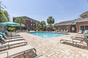 Columbia apartment for rent - clubhouse exterior, pool, lounge chairs and blue umbrella  at Vista Commons Apartments, Columbia, SC