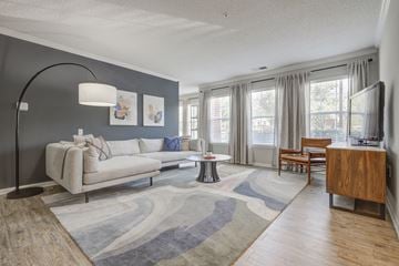 Columbia apartment for rent - A living room with a grey couch and a wooden cabinet.