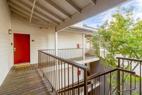 Martinez apartment for rent - A red door is on the left side of a white building.