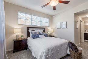 Parker apartment for rent - A bedroom with a bed, two nightstands with lamps, and a ceiling fan.