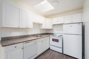 Daly City apartment for rent - A kitchen with white appliances and cabinets.