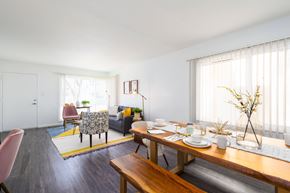 Daly City apartment for rent - the living room and dining area with a wooden table and chairs and a couch in the background