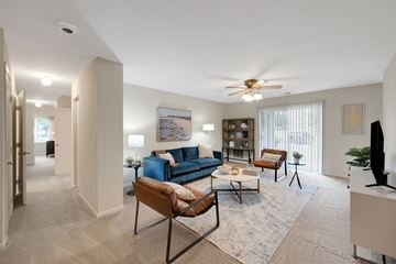 Woodbridge apartment for rent - A living room with a blue couch and a ceiling fan.