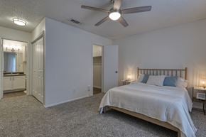 San Antonio apartment for rent - A bedroom with a bed, a dresser, and a ceiling fan.