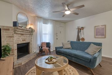 San Antonio apartment for rent - A living room with a blue couch and a fireplace.