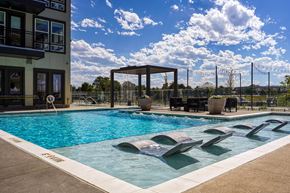 Aurora apartment for rent - a swimming pool at a hotel with a blue sky and clouds