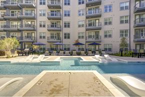 Dallas apartment for rent - A large swimming pool in front of apartment buildings.