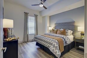 Austin apartment for rent - A bedroom with a large bed and a ceiling fan.