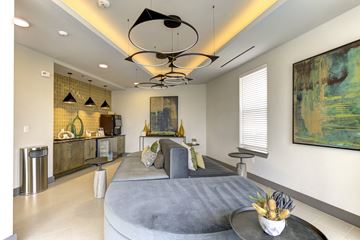 Austin apartment for rent - A modern living room with a grey sofa and a large abstract painting on the wall.