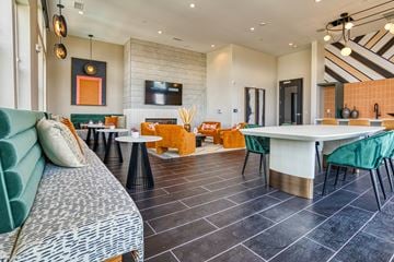 Aurora apartment for rent - A modern living room with a green sofa and a white dining table.