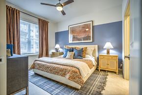 Dallas apartment for rent - A bedroom with a large bed and a ceiling fan.
