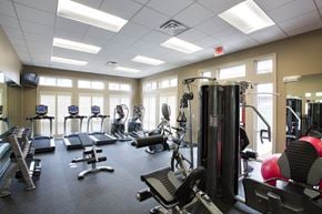 Wichita apartment for rent - A gym with a variety of equipment including treadmills, weights, and exercise machines.