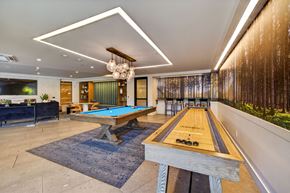 University Place apartment for rent - A pool table with a blue cloth and a wooden rack is in the middle of the room.