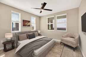 Sacramento apartment for rent - A bedroom with a large bed, a chair, and a ceiling fan.
