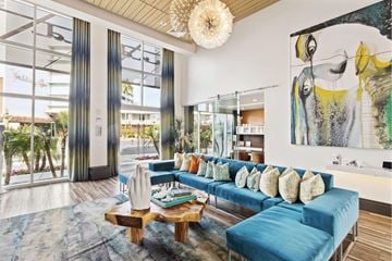 Scottsdale apartment for rent - A living room with a blue couch and a large painting on the wall.