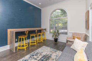 Atlanta apartment for rent - A living room with a grey couch, a wooden table and yellow chairs.