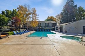 Santa Rosa apartment for rent - A large outdoor swimming pool surrounded by trees and a building.
