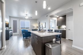 Folsom apartment for rent - A modern kitchen with a blue chair and a stainless steel trash can.