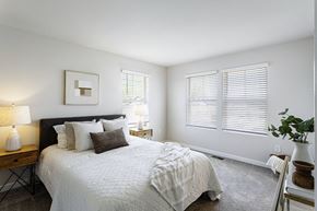 Waldorf apartment for rent - A bedroom with a large bed and a lamp on a side table.