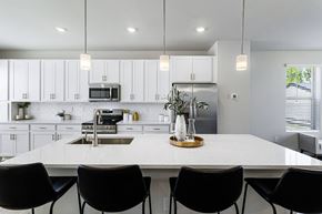 Waldorf apartment for rent - A modern kitchen with a white countertop and black chairs.