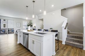 Waldorf apartment for rent - A modern kitchen with white cabinets and a wooden floor.
