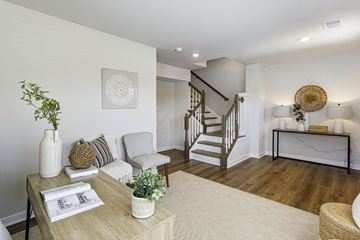 Waldorf apartment for rent - A living room with a staircase and a table with a plant on it.