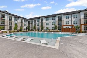 Aubrey apartment for rent - A large swimming pool in front of apartment buildings.
