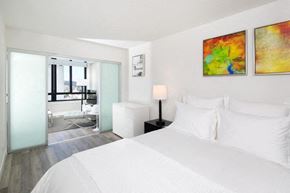 San Francisco apartment for rent - a bedroom with a white bed and two paintings on the wall