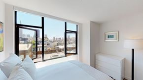 San Francisco apartment for rent - a bedroom with a large window and a white bed