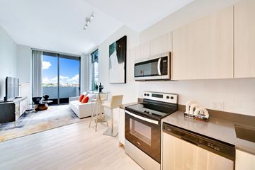Hollywood apartment for rent - A modern kitchen with a stove top oven and microwave above it.