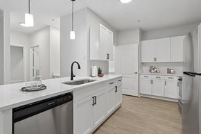 Chamblee apartment for rent - A modern kitchen with white cabinets and appliances.