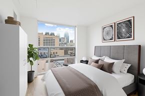 Philadelphia apartment for rent - A bedroom with a large bed and a view of the city.