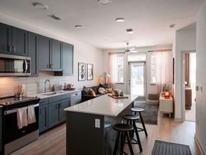 Denver apartment for rent - A modern kitchen with dark grey cabinets and a white countertop.