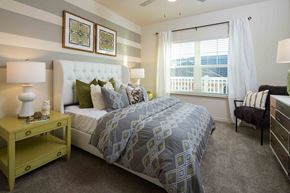 Tampa apartment for rent - A bedroom with a large bed and a window with white curtains.