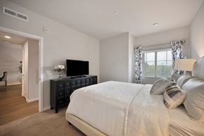 Chula Vista apartment for rent - A bedroom with a large bed and a TV on a dresser.