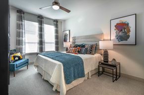 Flower Mound apartment for rent - a bedroom with a bed and a ceiling fan