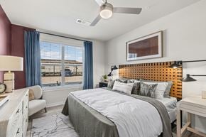 Denton apartment for rent - A bedroom with a large bed and a window overlooking a balcony.