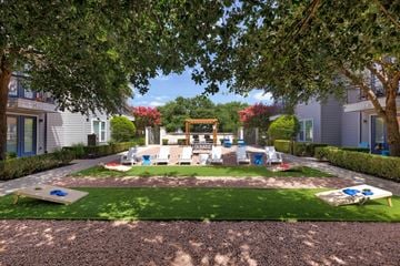 Austin apartment for rent - A playground area with a slide and swings surrounded by trees and houses.